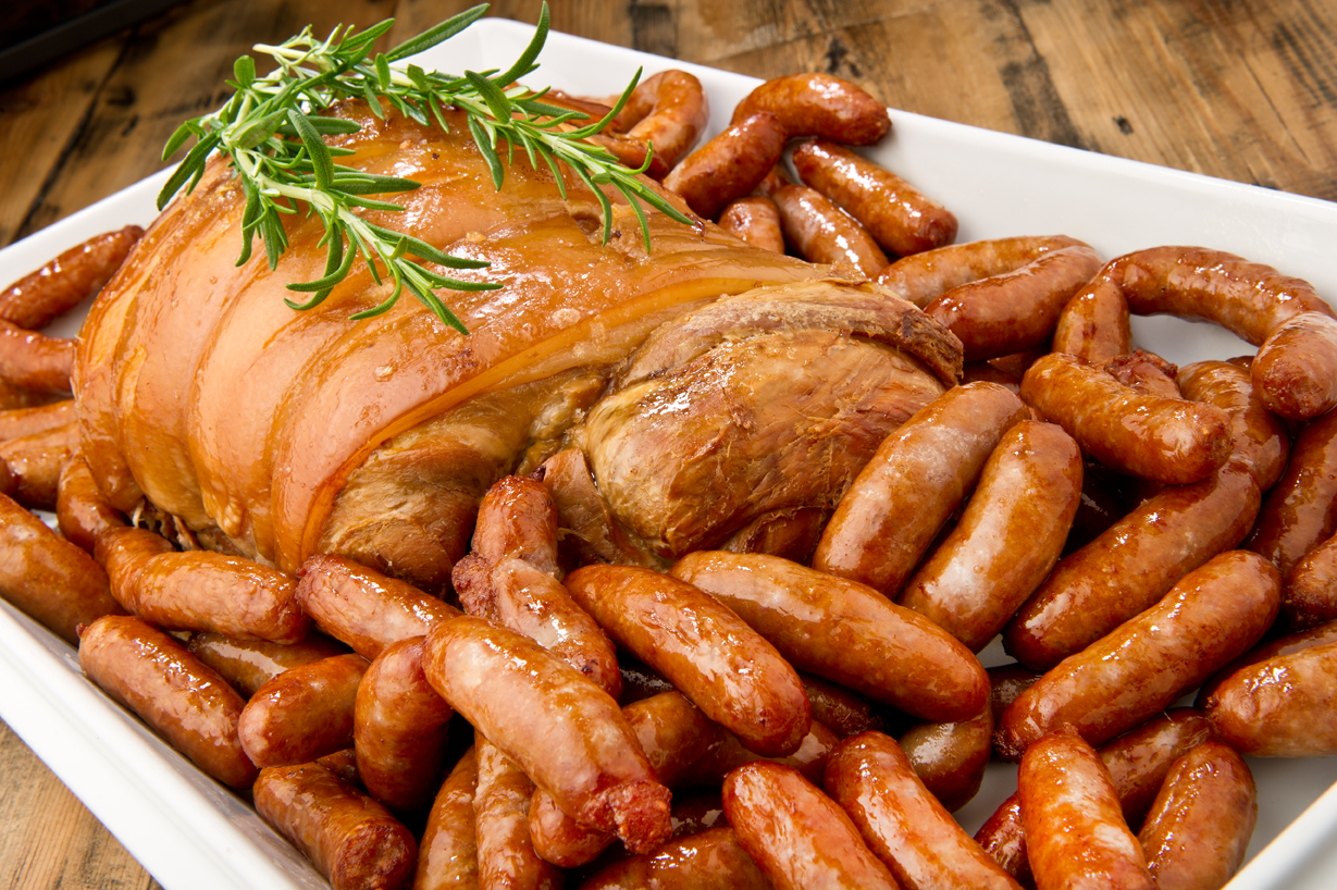 Roasted meat and sausages nicely presented in a white dish